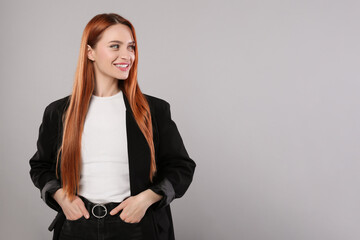 Portrait of beautiful young woman on light gray background, space for text