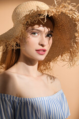 Beautiful young woman in sunlight on beige background