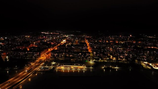 Aerial view in front of the illuminated skyline of Vaasa, night in Finland