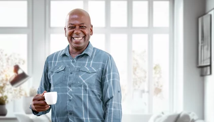 Fotobehang Happy Mature Black Man Drinking Coffee while relaxing at home. Retirement Lifestyle And Leisure Concept © NAMPIX