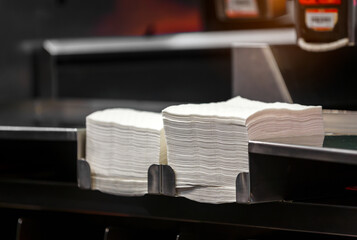 hand pick tissue paper and napkin pile on service table in restaurant 