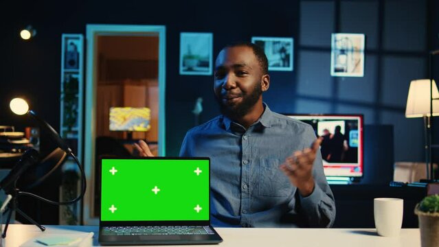 Tech online star filming green screen gaming laptop unboxing, giving reasons to purchase it. Influencer capturing video urging social media followers to buy isolated screen notebook
