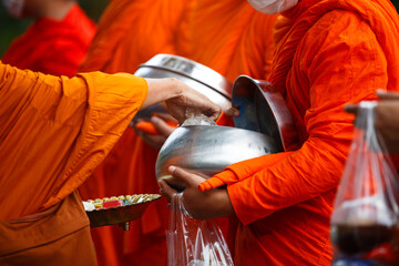 Buddhist monk holding alms bowl waitting for buddhism make merit by offering food and water at...