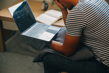 Fototapeta premium Alone man silhouette staring at the window closed with curtains in bedroom. Man stands at window alone