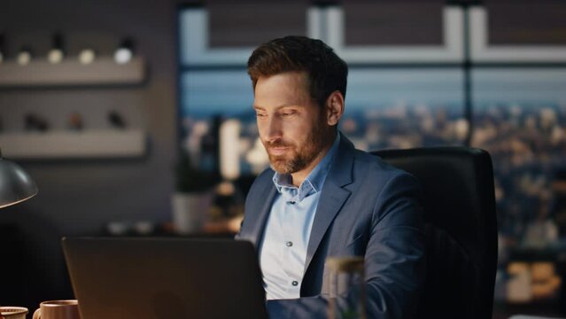 Closeup smiling boss sipping coffee office late night. Director looking laptop