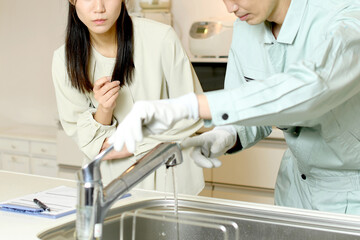 Fototapeta premium キッチンで会話をする男性作業員と女性客 