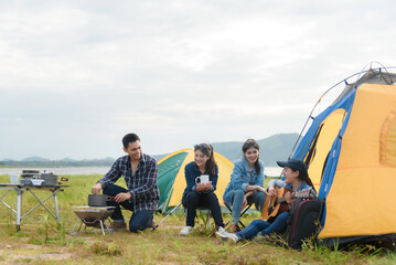 Group of friends walking on an adventure in the forest Camping, relaxing, happy, playing guitar, singing, drinking coffee.