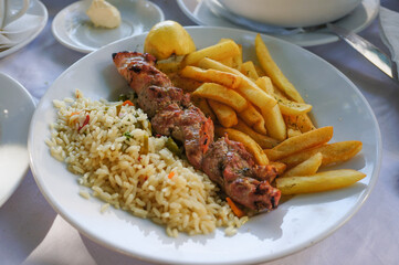 Souvlaki served with rice and potato chips in Athens