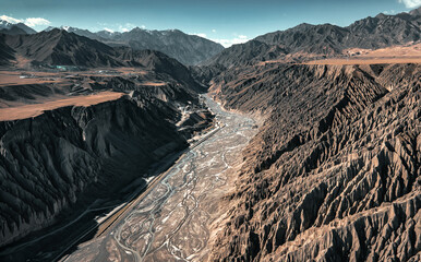 The aerial view of the mud volcano and the running river in Dushanzi Grand Canyon