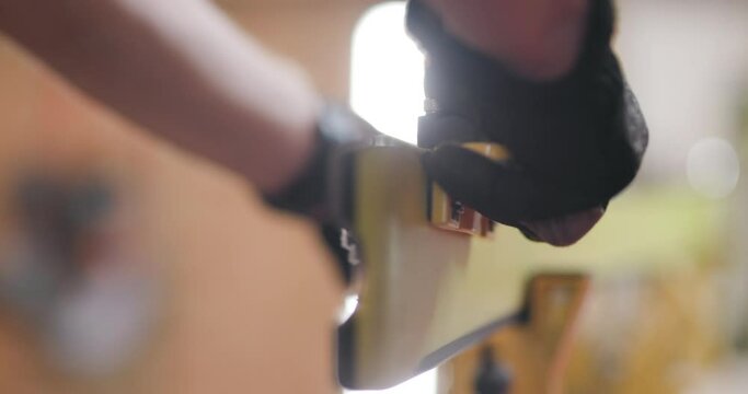 Man servicing skis. Abstract male hands working with special equipment. Sharpening the ski edge. Close up video recorded with cinema camera.