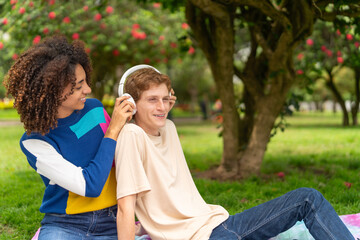 Lovers enjoying music during picnic in a park