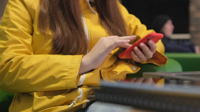 Digital Nomad Vibes: Cafe Chronicles of a Social Media Maven. A young freelance woman uses her smartphone to communicate on social media and surf the internet. 4K