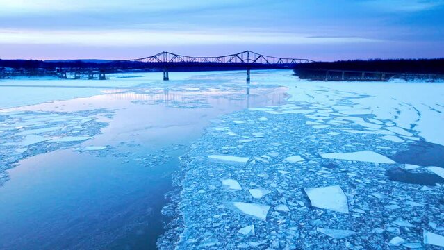 An overhead drone shot capturing the enormity of ice masses drifting in the water.