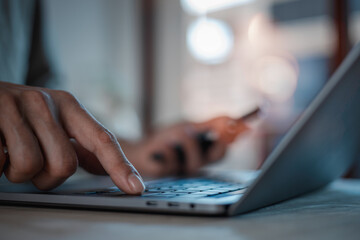 Hand of young man using laptop on table at home social media online content, freelance worker, working online, content creator,  man reading blog online on computer