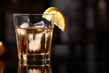 Glass of cold rum on table in bar, closeup