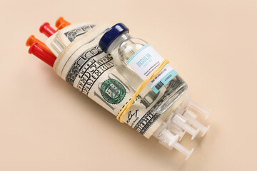 Insulin with syringes and money on beige background. Expensive medicine concept