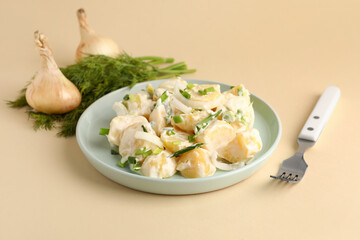 Plate of tasty Potato Salad with greens on yellow background