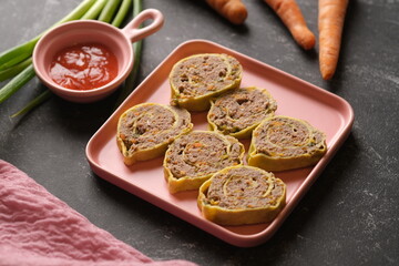 Rolade Daging Sapi. Beef roulade on a square pink ceramic plate. Made from ground beef, pepper,...