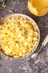 Bowl of tasty Italian pasta with Cheddar cheese on grunge background