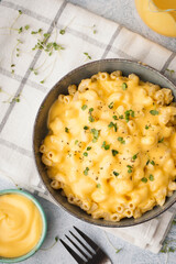 Bowl of tasty Italian pasta with Cheddar cheese on table