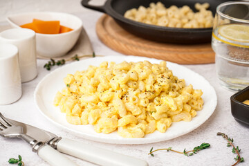 Plate of tasty Italian pasta with Cheddar cheese on light background