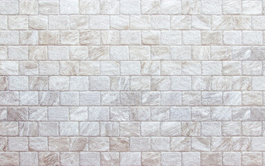 Obraz premium Empty background of wide cream brick wall texture. Beige old brown brick wall concrete or stone textured, wallpaper limestone abstract flooring. Grid uneven interior rock. Home decor design backdrop.