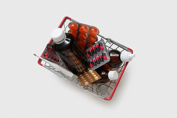 Mini shopping basket with different pills on white background