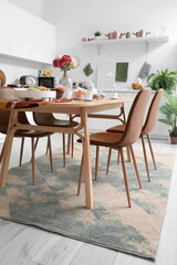 Served dining table on stylish carpet in modern kitchen
