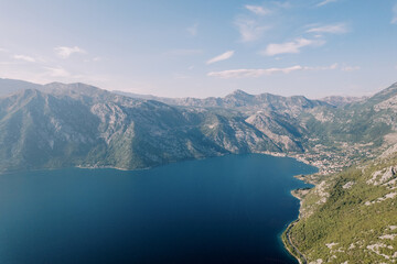 Fototapeta na wymiar Bay of Kotor is surrounded by a green mountain range. Montenegro. Drone