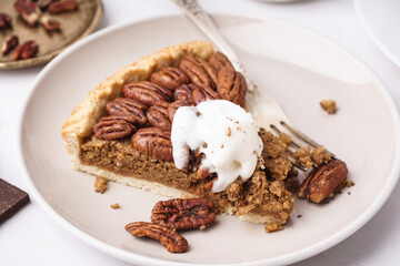 Plate with piece of tasty pecan pie on grey background