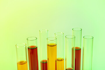Test tubes with different samples on colorful background, closeup