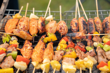 Assorted delicious grilled meat with vegetables on barbecue grill with smoke and flames. Grilling...