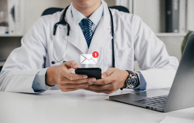 Doctor using smartphone for telemedicine and consult email with notification alert, Online...