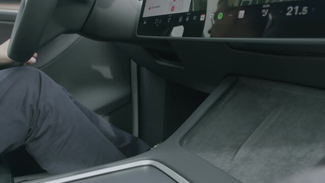 Seamless tech: Smartphone unplugged from Tesla's Qi charger as driver exits.