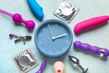 Alarm clock with different toys and condoms on gradient background. Time for sex