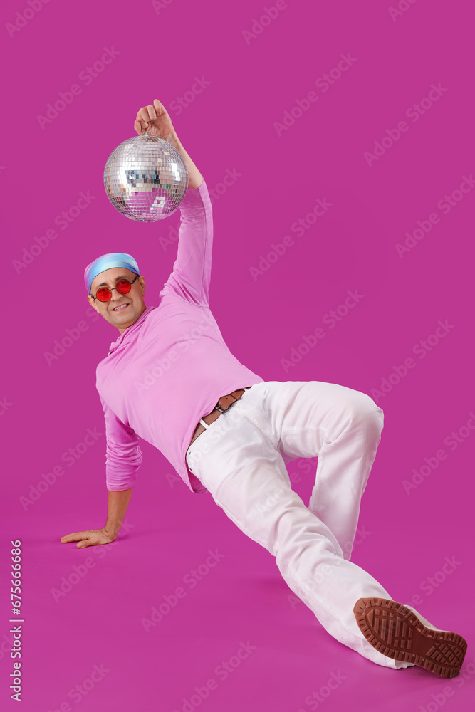 Poster Cool mature man with disco ball dancing on purple background