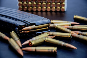 bullets with rifle frame and ammo on black table