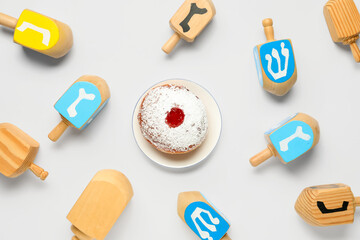Hanukkah composition with dreidels and donut on white background