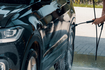 Car washing with a high pressure water jet at an outdoor self-service  car wash station
