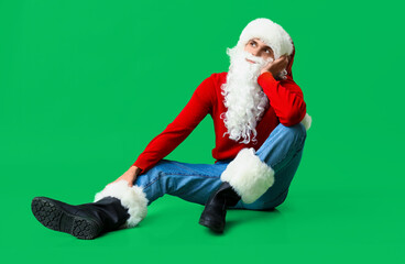 Thoughtful Santa Claus on green background