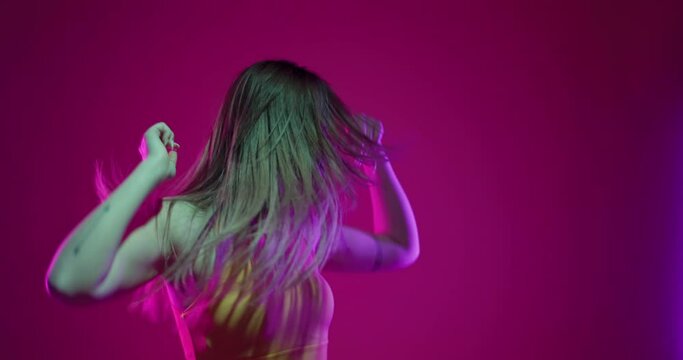 Girl dancing hip hop slow motion video. Female clubbing at disco party with colorful flashes of light on dark background.