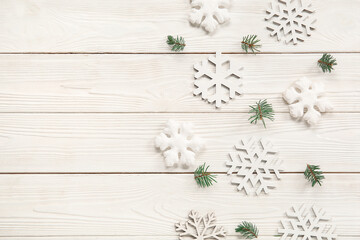 Beautiful snowflakes with fir branches on white wooden background