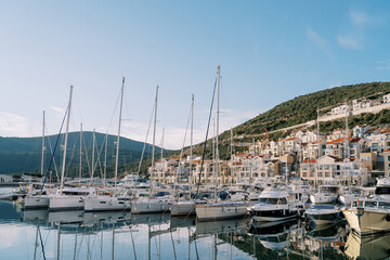 Fototapeta na wymiar Lustica bay marina with moored sailing yachts and colorful villas. Montenegro