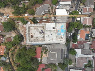 New office building under construction. construction site with yellow tower cranes and machinery. aerial top view.