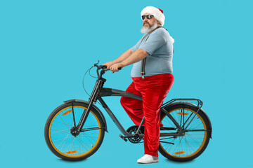 Obraz premium Cool Santa Claus with bicycle on blue background