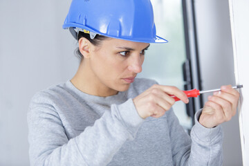 woman builder screwing window frame