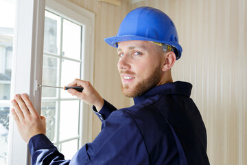 professional contractor using screwdriver on window