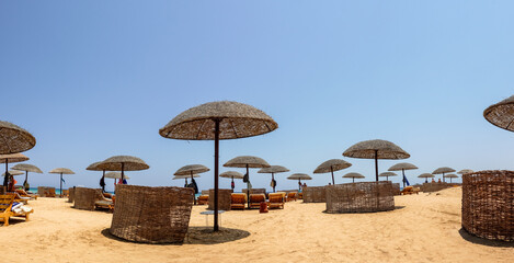 beach area with umbrellas and beach chairs with sand and deep blue sky on vacation in egypt panorama