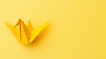 yellow origami bird on the yellow background