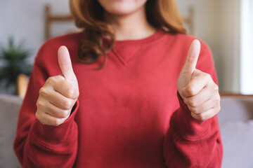 Closeup of a woman making and showing thumbs up hand sign